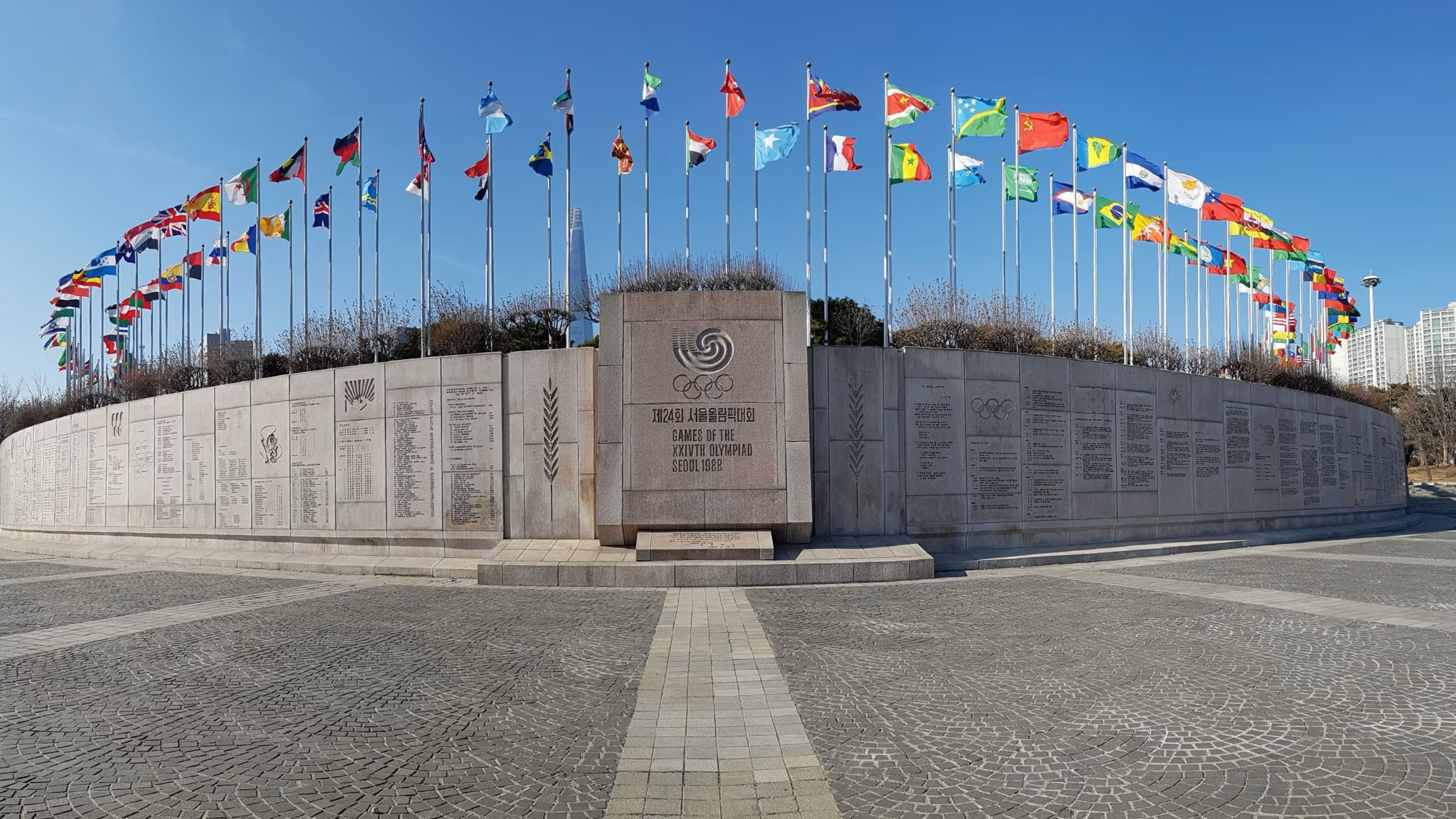International student finding their country's flag at the 1988 Olympic flag plaza in Olympic Park Seoul